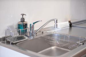 a kitchen sink with a dish rack in it at Yukari B in Asahikawa +40 photos
