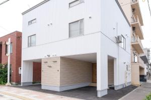 a white house with a large garage at Yukari B in Asahikawa
