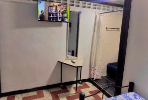 a room with a table and a tv on the wall at Hotel Bachue Ibagué in Ibagué