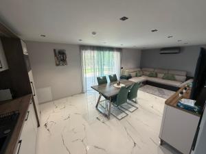 a kitchen and living room with a table and chairs at Guest Apartman in Tiszakécske