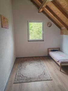 a room with a bed and a window and a rug at Green Escape in Zavidovići