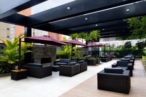 a restaurant with purple umbrellas and tables and chairs at NH Collection Curitiba in Curitiba