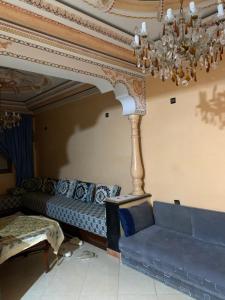 a living room with a blue couch and a chandelier at Rayan in Tangier