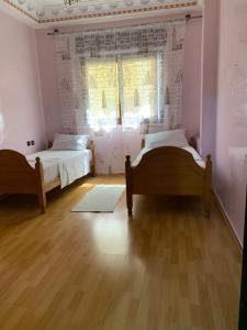 a bedroom with two beds and a window at Rayan in Tangier