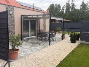 a patio with a table and chairs and a fence at Guest Apartman in Tiszakécske