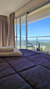 a bedroom with a large bed with a large window at Arenas del Este in Costa del Este