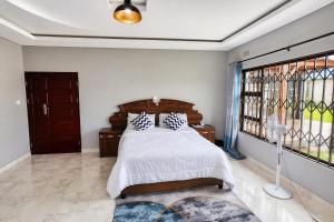 a bedroom with a bed and a large window at Chic Modern Escape in Lusaka