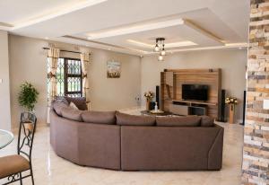 a living room with a large couch and a tv at Chic Modern Escape in Lusaka