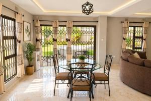 a dining room with a glass table and chairs at Chic Modern Escape in Lusaka