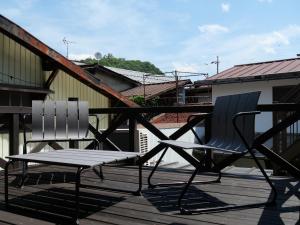 two chairs and a bench on a deck at 卌屋 shioya in Gujo