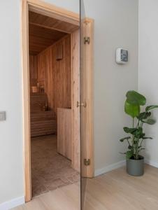 a glass door leading into a room with a closet at Lapsiņmuiža Pool House - Pool, Sauna & Hot-tub included in Dzedri