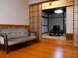 a living room with a couch and a television at 卌屋 shioya in Gujo