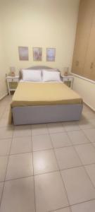 a bedroom with a bed and two night stands at Nicol's apartment in Ermoupoli