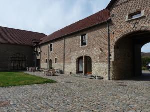 ein großes Backsteingebäude mit einem Innenhof aus Stein in der Unterkunft B&B Espace Tello in Jodoigne