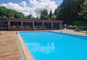 a large blue swimming pool in front of a building at Waters Edge Lodge in Caeathro