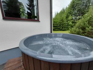 a large bath tub sitting outside of a building at Lapsiņmuiža Pool House - Pool, Sauna & Hot-tub included in Dzedri +21 photos