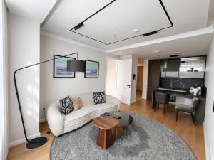 a living room with a white couch and a table at Mandala 365 Residential Tower in Ulaanbaatar