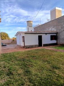 a white building with a door in a yard at La casita de José in Villa Unión