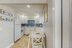 a kitchen with a table and a white refrigerator at Sea Pirate 1 in Holmes Beach +15 photos