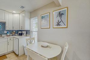 a kitchen with a white table and a table and chairs at Sea Pirate 1 in Holmes Beach