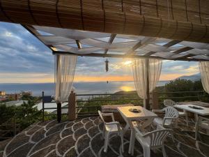 a patio with tables and chairs and a view of the ocean at Rooms to let Spiropali in Piqeras