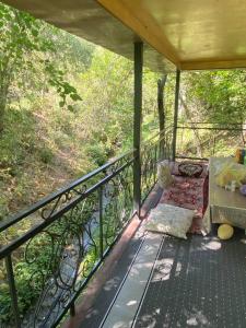 a porch with a bed on a balcony at Ikhtiyor guest house with mountainiring hiking horse riding serivices in Yukary-Ukhum +55 photos