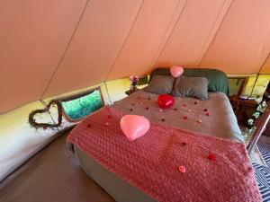 a bed in a tent with hearts on it at Lagom - Logeren in 't groen in Nieuwerkerken