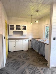 a kitchen with white cabinets and a counter top at Sosenkowe Zacisze in Ciche