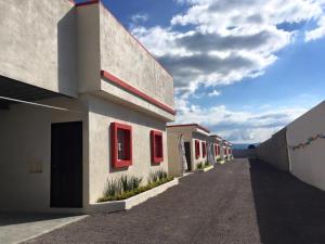 a row of buildings with red windows on a street at Hotel Panamericano in Jocotitlán