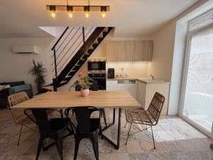 a kitchen and dining room with a wooden table and chairs at La Suite Celeste in Nuits-Saint-Georges