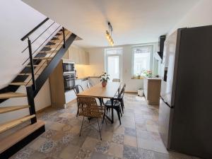 a kitchen and dining room with a table and a staircase at La Suite Celeste in Nuits-Saint-Georges