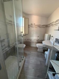 a bathroom with a shower and a toilet and a sink at La Conchiglia 2.0 in Soverato Marina +13 photos