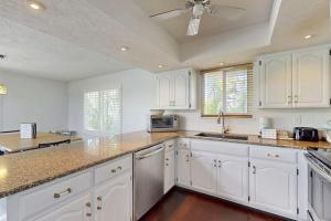 a kitchen with white cabinets and granite counter tops at Spring Oasis in Anna Maria +17 photos