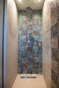 a shower in a bathroom with a tile wall at Maresol Villa in Nea Kallikrateia +200 photos