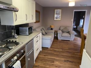 a kitchen and living room with a stove and a couch at Rose cottage in Wellington +20 photos