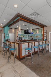 a bar in a restaurant with chairs and a counter at The Strand - A Boutique Resort in Myrtle Beach