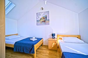 a bedroom with two beds and a painting on the wall at Villa Valentina with pool and close to beach in Selca +25 photos