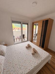ein Schlafzimmer mit einem Bett, auf dem zwei Hausschuhe liegen in der Unterkunft Apartment EDA in Bosanska Krupa
