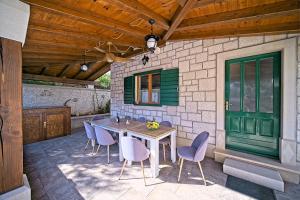 a patio with a table and chairs and a green door at Villa Valentina with pool and close to beach in Selca