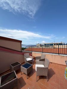 a balcony with chairs and a table on a roof at La Conchiglia 2.0 in Soverato Marina