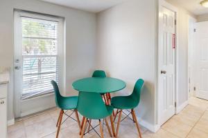a green table and chairs in a room with a window at Gertie's Lime House in Holmes Beach