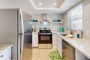 a kitchen with a stainless steel refrigerator and a sink at Gertie's Lime House in Holmes Beach