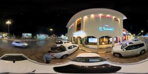 a man is standing in front of a car dealership at شقق ابراهيم ناصر الضاوي للشقق المخدومة in Al Majma'ah