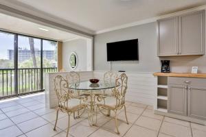a kitchen with a table and chairs and a tv at Midnight Cove II 823 in Siesta Key