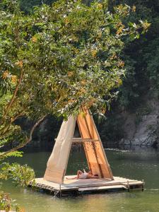 a person laying on a raft in the water at Rio Hostel Buritaca in Buritaca
