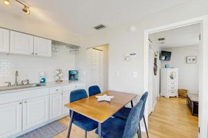 a kitchen and dining room with a wooden table and chairs at Bay View Inn 202 in Bradenton Beach
