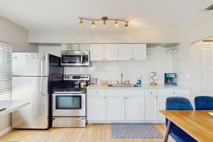 a kitchen with white cabinets and stainless steel appliances at Bay View Inn 202 in Bradenton Beach