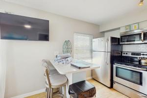 a kitchen with a small table and a refrigerator at Bay View Inn 202 in Bradenton Beach +25 photos