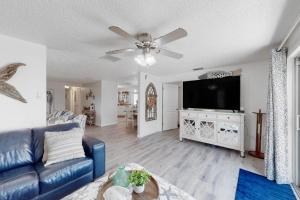 a living room with a blue couch and a flat screen tv at Casa de Brayli in Cortez