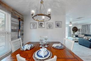 a dining room with a wooden table and a chandelier at Casa de Brayli in Cortez +19 photos